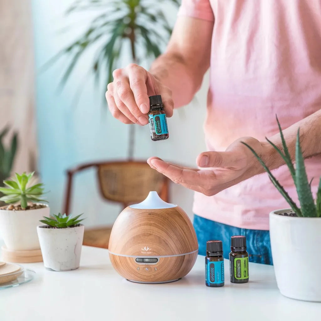 a person holding a bottle of essential oils in their hands